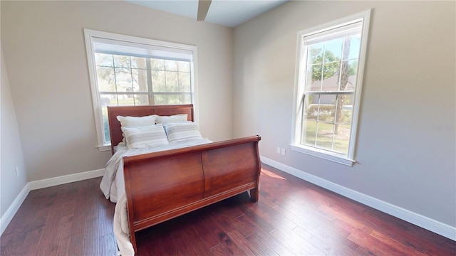 bedroom with dark wood finished floors and baseboards