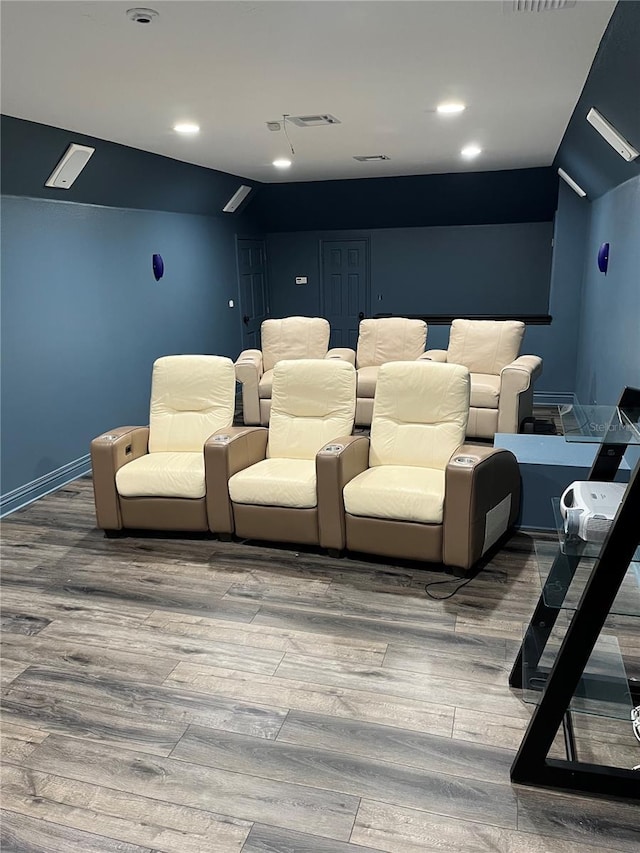 cinema room featuring visible vents, baseboards, and wood finished floors