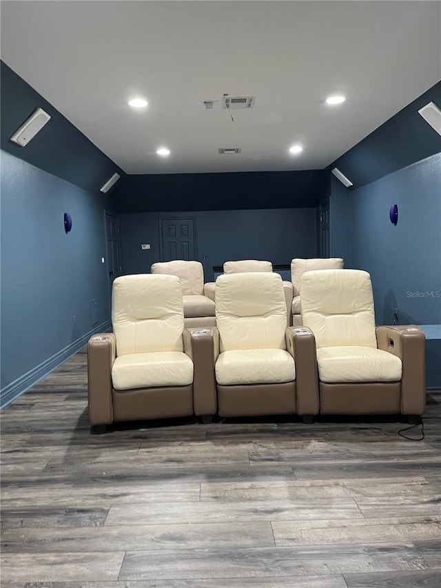 cinema featuring visible vents, lofted ceiling, baseboards, and wood finished floors