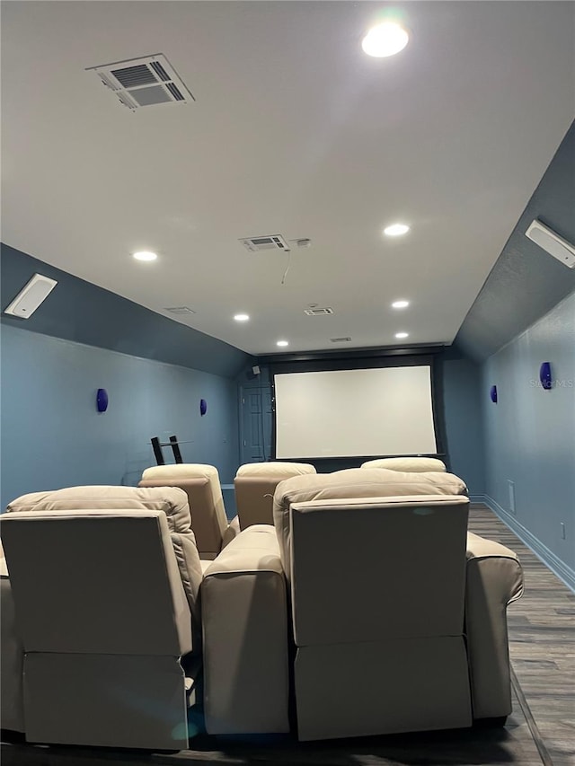 cinema featuring wood finished floors, visible vents, baseboards, recessed lighting, and vaulted ceiling