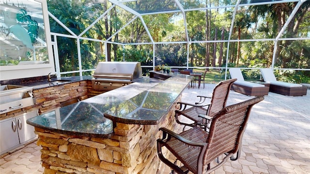 view of patio with exterior kitchen, grilling area, outdoor dry bar, and a lanai