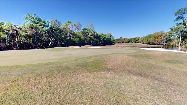 surrounding community with a lawn and golf course view