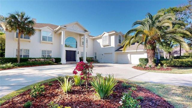 view of front of house with stucco siding, concrete driveway, and an attached garage