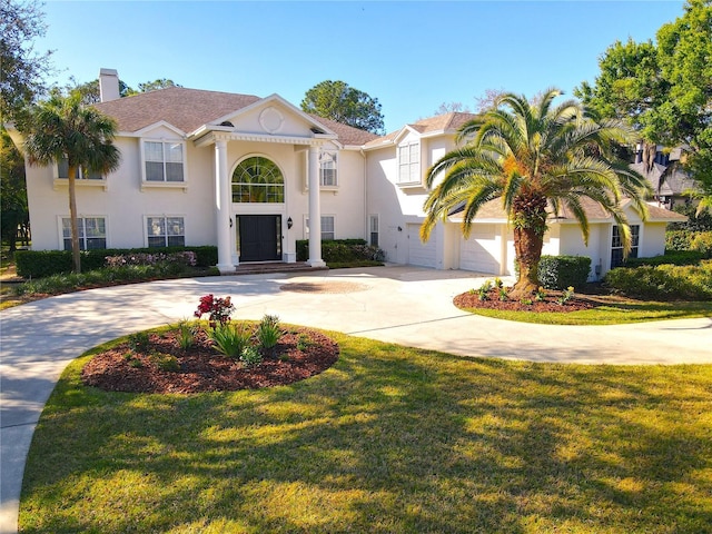 view of front of home featuring concrete driveway, a front lawn, and stucco siding