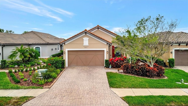 view of front of home featuring stucco siding, an attached garage, a tile roof, and decorative driveway