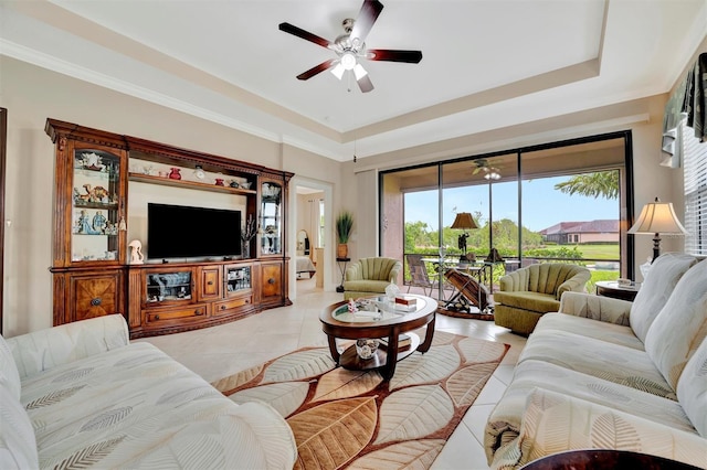 living area featuring light tile patterned floors, a tray ceiling, and ceiling fan