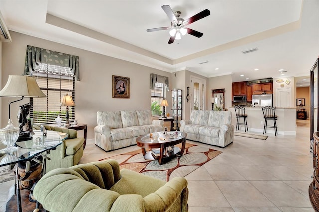 living area featuring visible vents, a raised ceiling, and light tile patterned flooring