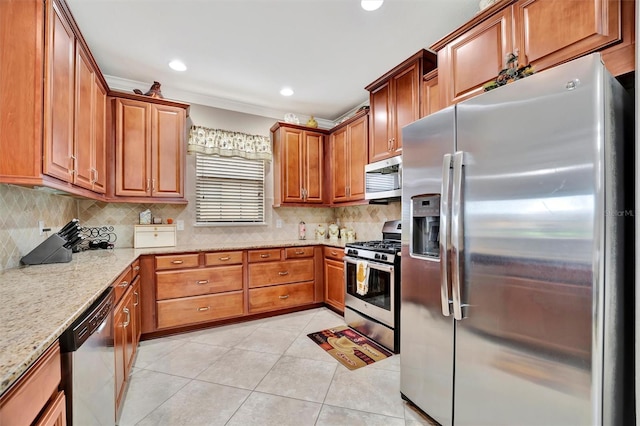 kitchen with backsplash, light stone counters, light tile patterned flooring, and appliances with stainless steel finishes