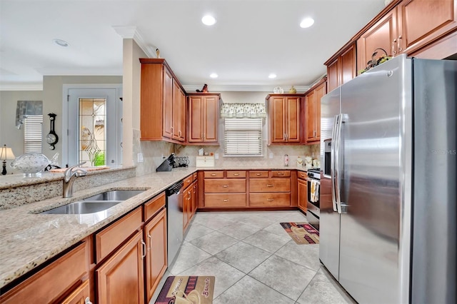 kitchen with a sink, appliances with stainless steel finishes, crown molding, light tile patterned floors, and light stone countertops