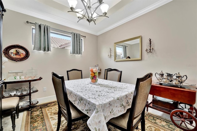 dining area with a notable chandelier, baseboards, and ornamental molding