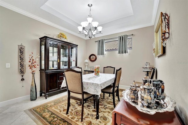 dining space featuring baseboards, ornamental molding, light tile patterned flooring, a notable chandelier, and a raised ceiling