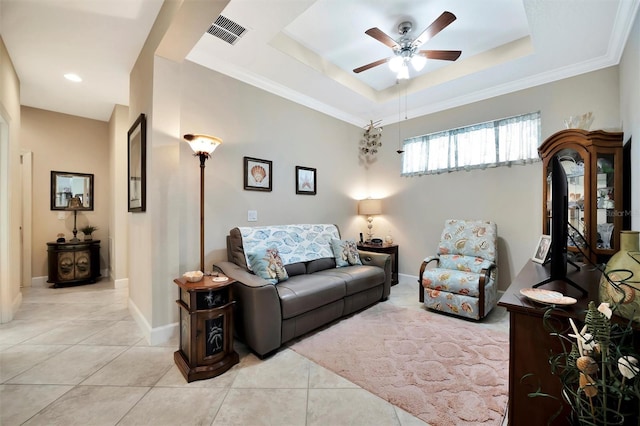 living area featuring light tile patterned floors, a ceiling fan, baseboards, visible vents, and a raised ceiling