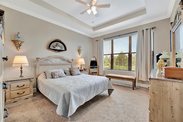 bedroom featuring crown molding, baseboards, ceiling fan, light carpet, and a raised ceiling