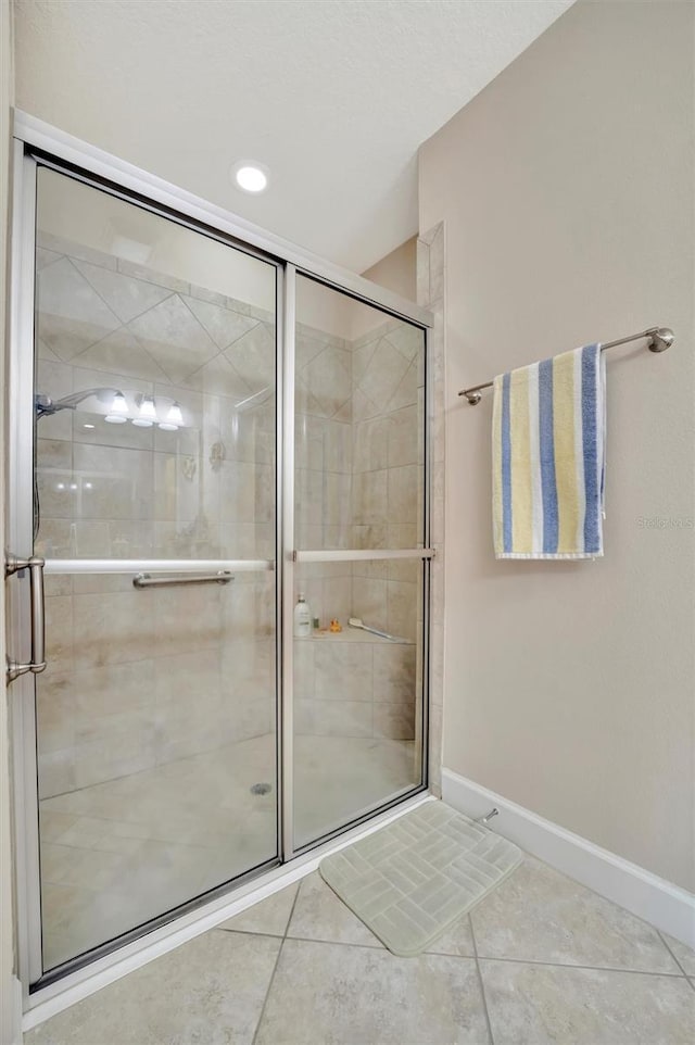 full bathroom with baseboards, a shower stall, and tile patterned flooring