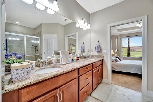 bathroom featuring a sink, a shower stall, double vanity, and tile patterned flooring