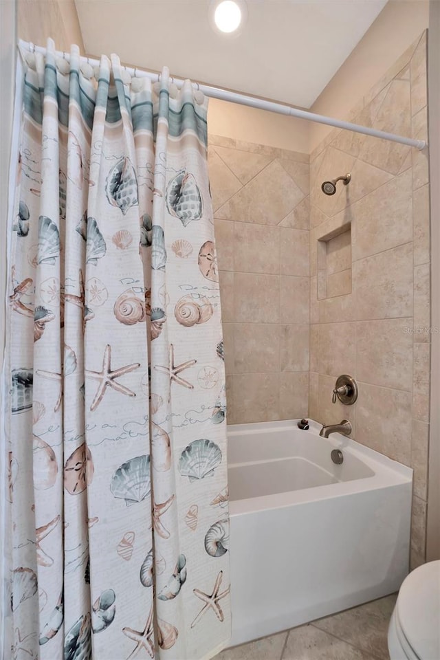 full bathroom featuring tile patterned floors, toilet, and shower / bath combination with curtain