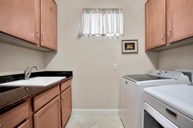 laundry area with light tile patterned floors, baseboards, cabinet space, separate washer and dryer, and a sink