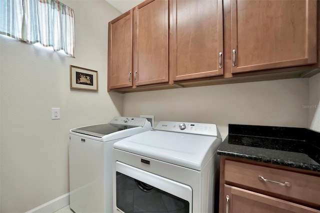 laundry room with baseboards, cabinet space, and separate washer and dryer