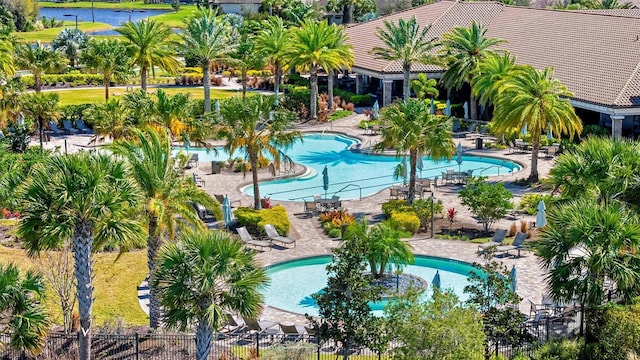 community pool with a patio area and fence
