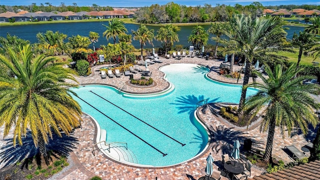 view of swimming pool with a residential view, a patio, and a water view