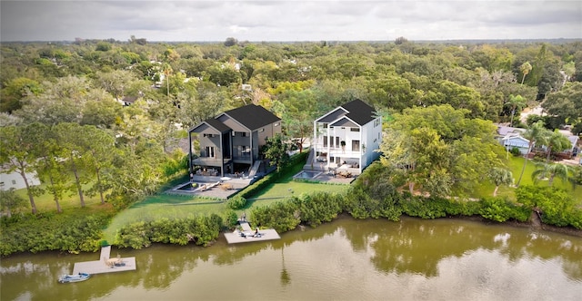 birds eye view of property featuring a wooded view and a water view