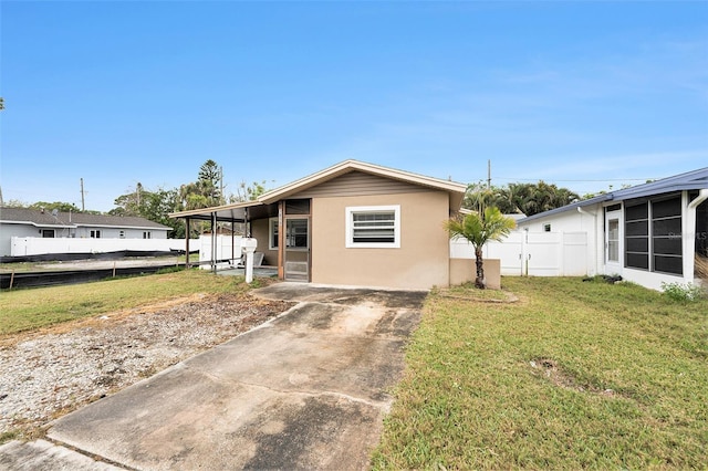 view of front of home featuring stucco siding, a front yard, and fence