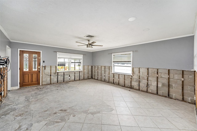 unfurnished room featuring visible vents, a wainscoted wall, ceiling fan, and ornamental molding