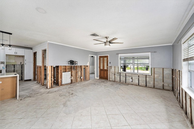 unfurnished living room featuring visible vents, light tile patterned flooring, ceiling fan, a textured ceiling, and crown molding