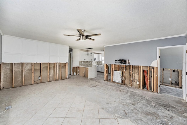 unfurnished living room featuring a textured ceiling, ceiling fan, and ornamental molding