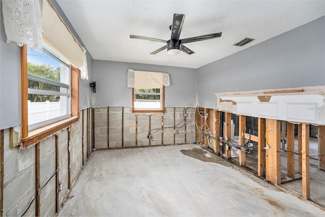 unfurnished room featuring a textured ceiling, visible vents, and ceiling fan