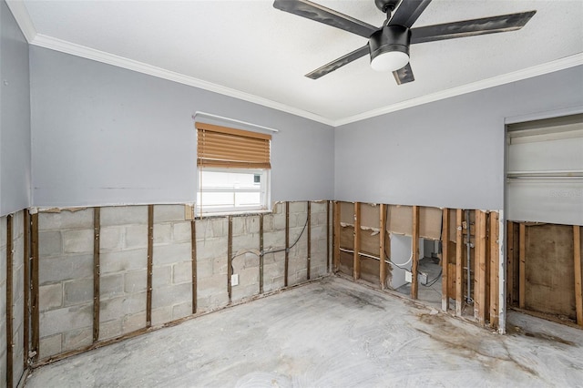 empty room featuring ceiling fan, concrete block wall, and ornamental molding