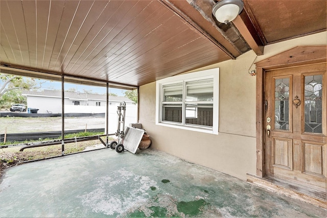 unfurnished sunroom with wood ceiling