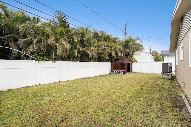 view of yard with an outbuilding, central AC unit, a storage unit, and a fenced backyard