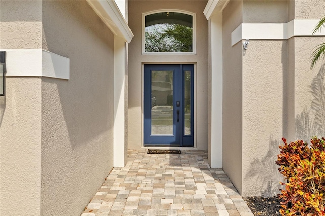 entrance to property featuring stucco siding