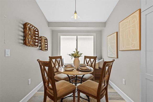 dining area featuring baseboards and light wood finished floors