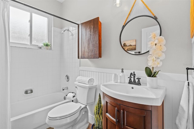 bathroom with vanity, toilet, bathtub / shower combination, and a wainscoted wall