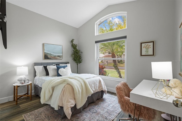 bedroom featuring baseboards, wood finished floors, and vaulted ceiling