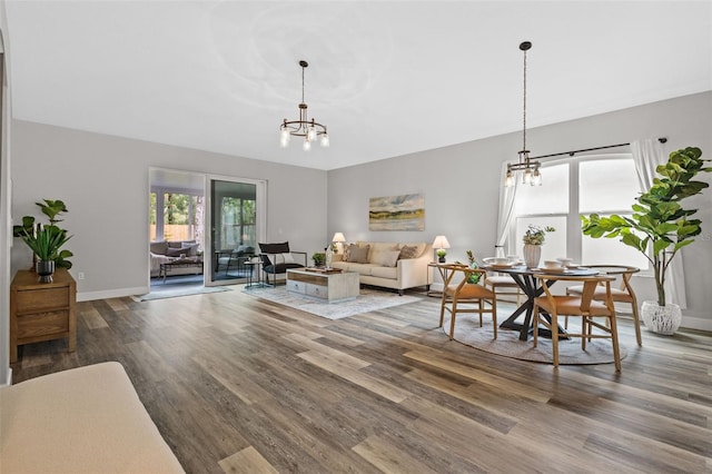 living room featuring an inviting chandelier, wood finished floors, and baseboards