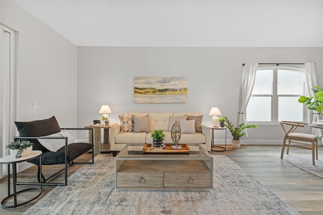 living area with baseboards and wood finished floors