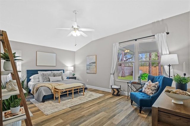 bedroom with baseboards, a ceiling fan, lofted ceiling, and wood finished floors