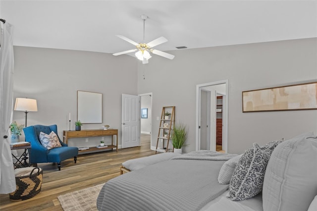 bedroom featuring ceiling fan, visible vents, high vaulted ceiling, and wood finished floors