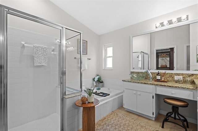 bathroom featuring tile patterned floors, a garden tub, a shower stall, vanity, and vaulted ceiling