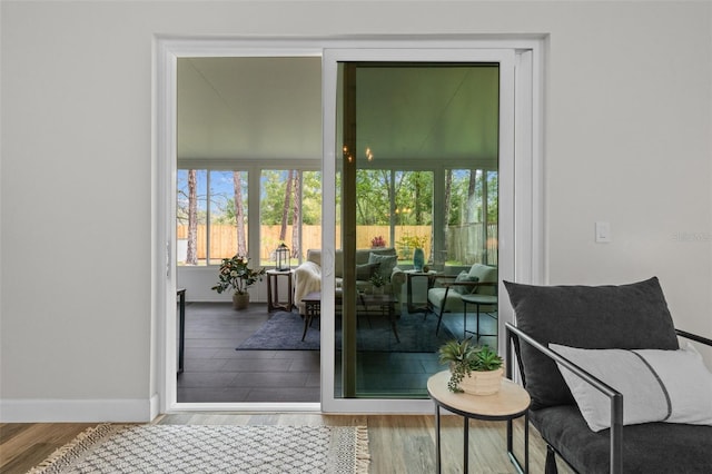 doorway to outside featuring baseboards and wood finished floors