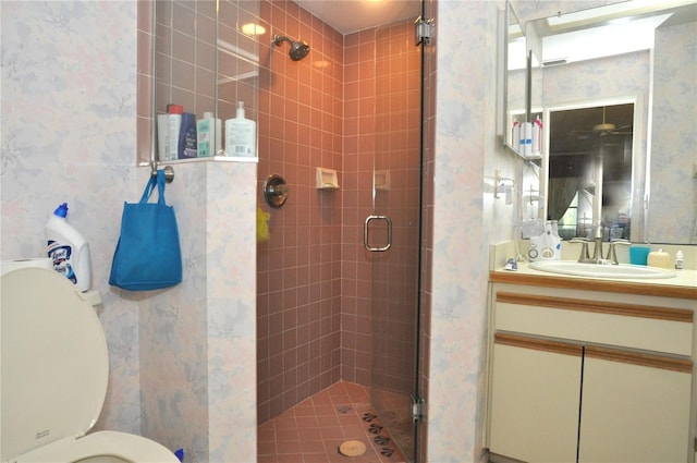 full bath featuring vanity, toilet, a shower stall, and wallpapered walls