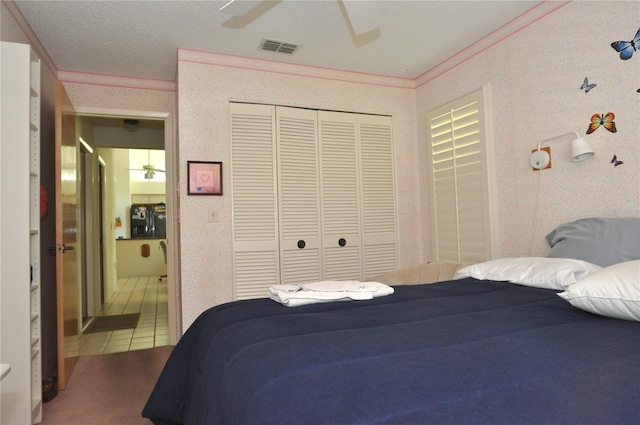 bedroom with visible vents, tile patterned floors, wallpapered walls, crown molding, and a closet