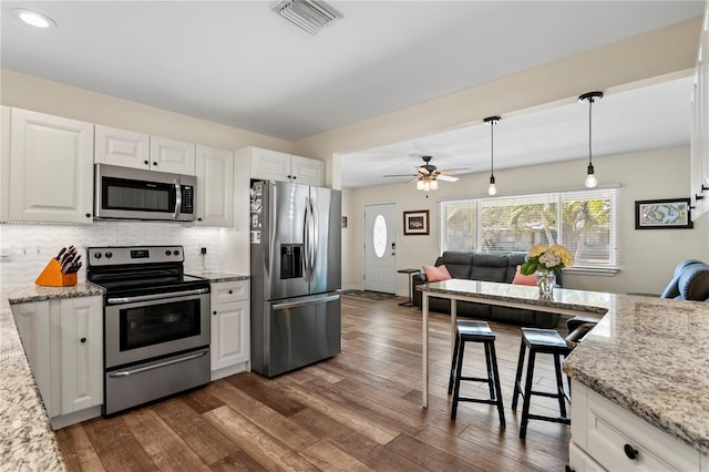 kitchen featuring visible vents, tasteful backsplash, dark wood-type flooring, and appliances with stainless steel finishes