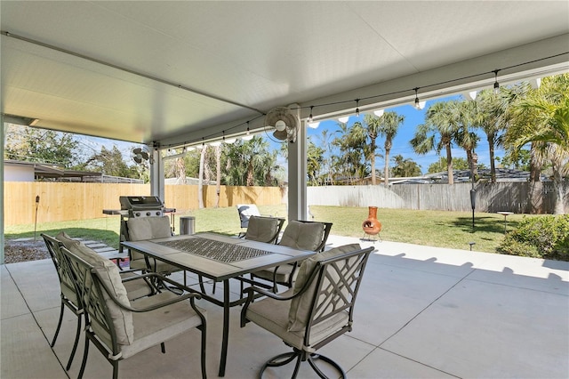 view of patio with outdoor dining area, a grill, and a fenced backyard