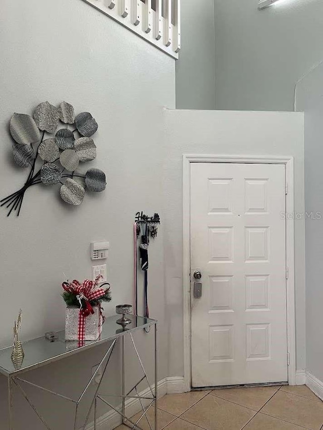 entryway with light tile patterned floors and baseboards