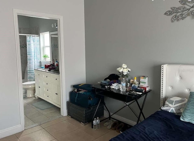 bedroom with tile patterned flooring and connected bathroom