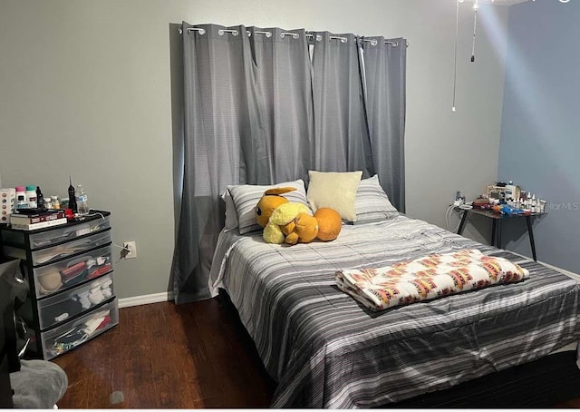 bedroom featuring baseboards and wood finished floors